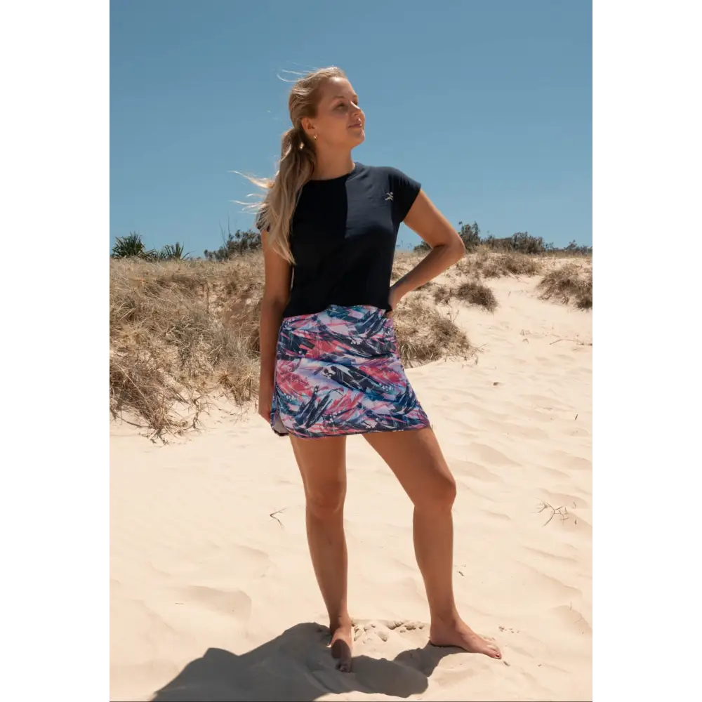 Skort with an abstract print design in vibrant pink, white, and navy blue, including practical pockets on the undershorts