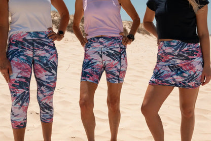 Skort with an abstract print design in vibrant pink, white, and navy blue, including practical pockets on the undershorts. shows Astrid 3/4 legging and astrid bike shorts