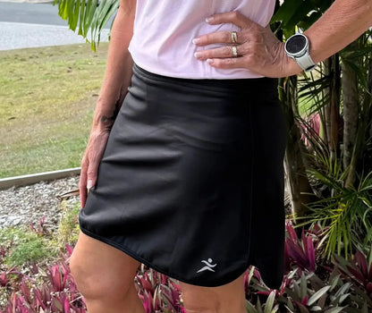 Black longer skort in athletic fabric with pockets and subtle white logo suitable for golf and lawn bowls
