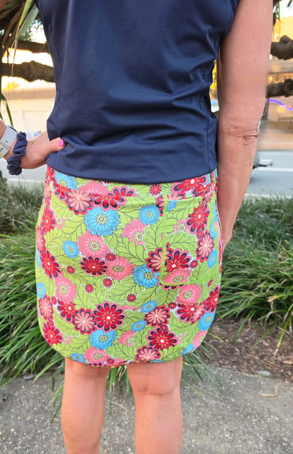 Cara longer skort with pockets in vibrant green featuring bold pink red and blue floral pattern and mini skirt style