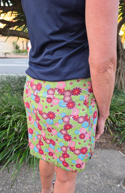 Cate skort with pockets featuring a vibrant green floral pattern with pink red and blue flowers and leaf accents