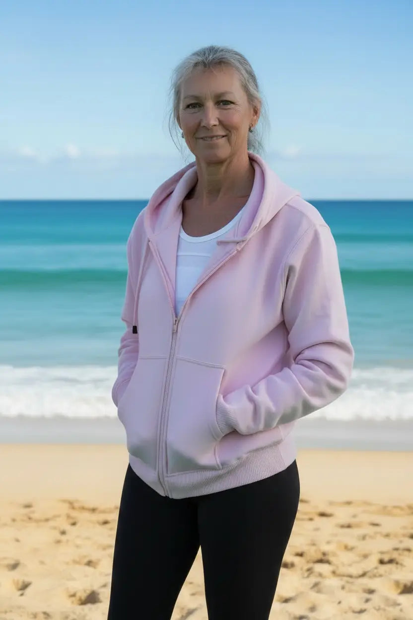 A soft pink fleecy zip hoodie with hood and front pockets worn over a white top in fleecy zip hoodies collection