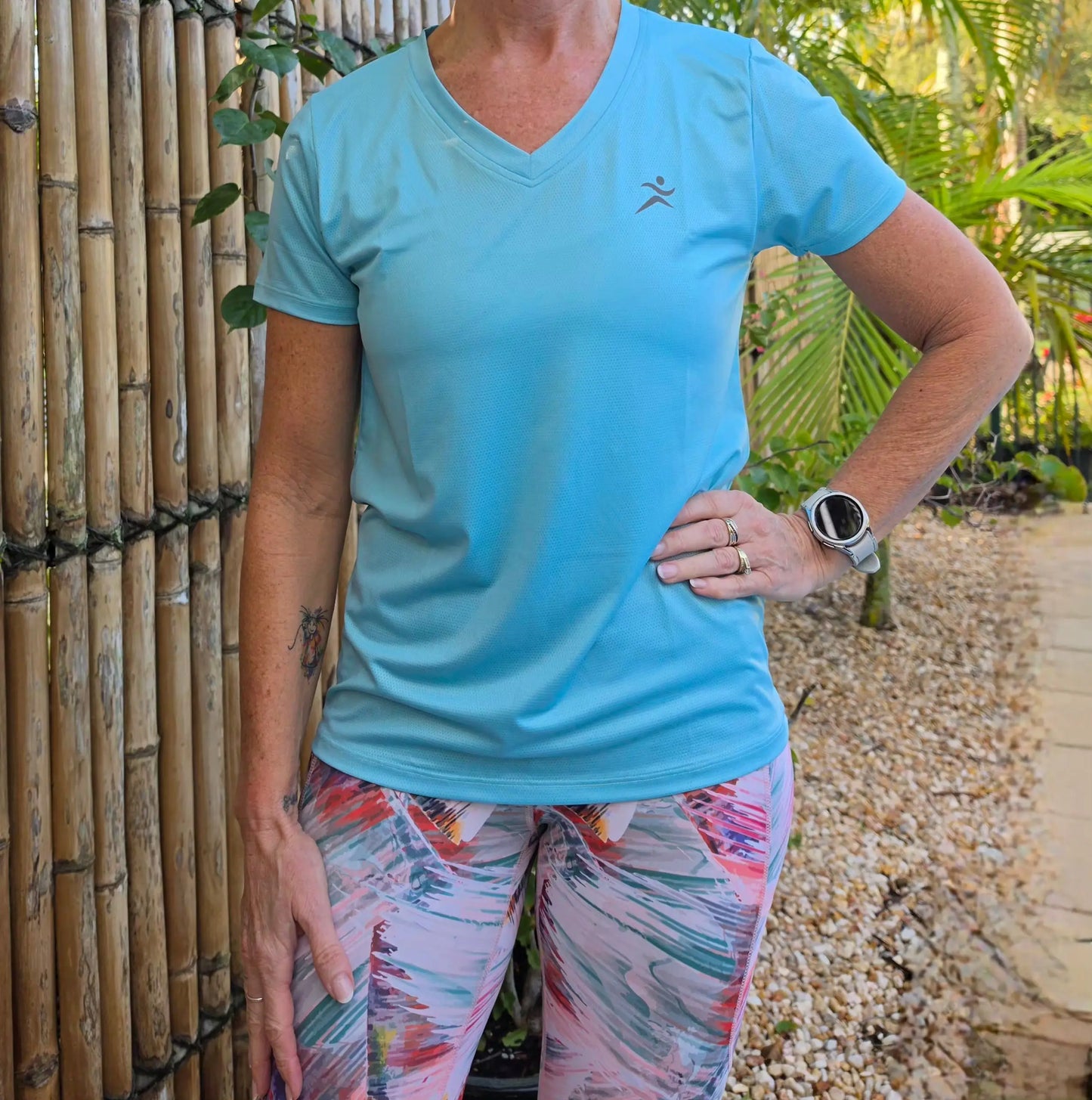 Light blue gmaxx mesh lightweight v-neck activewear top with dark gray running figure logo on left chest in sizes XS to 3XL