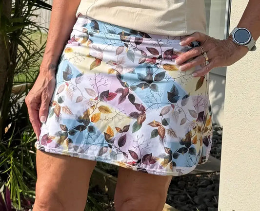 Laini skort with pockets featuring a colorful autumn leaf pattern on pastel background perfect for activewear use