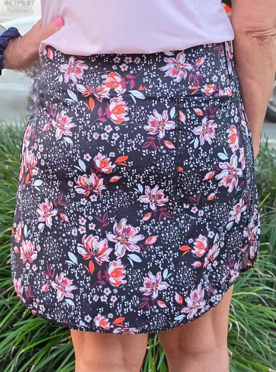 Black floral-patterned morgan longer skort with pockets featuring pink and orange blossoms and small white dots