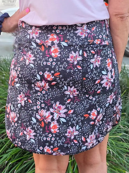 Black floral-patterned morgan longer skort with pockets featuring pink and orange blossoms and small white dots