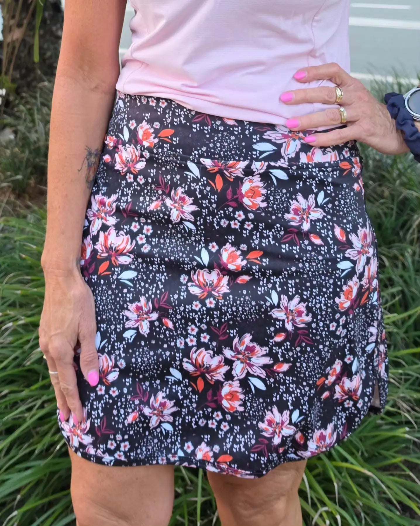 Morgan longer skort with pockets featuring a black floral print mini skirt with pink white and orange blossoms and green leaves