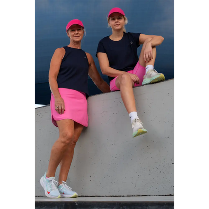 A pink skort features an outer skirt layer and attached undershorts with visible pockets on the thighs.