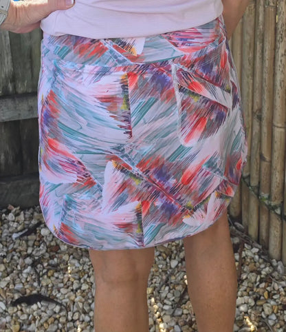 TonI longer length skort with pockets in vibrant pink teal red and purple abstract pattern made of soft stretchy fabric