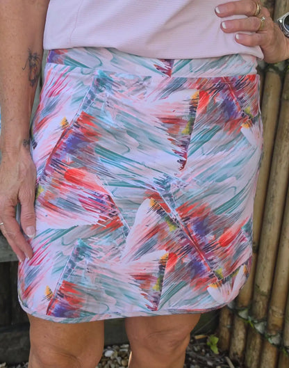 Vibrant cara longer skort with pockets in pink teal and orange abstract brushstroke patterns in longer length design